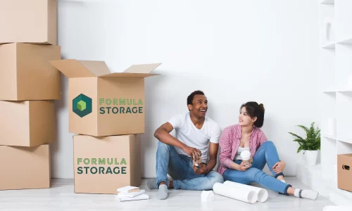 Happy couple sitting on the fresh and clean floors at Formula Storage self storage units facility in Brampton